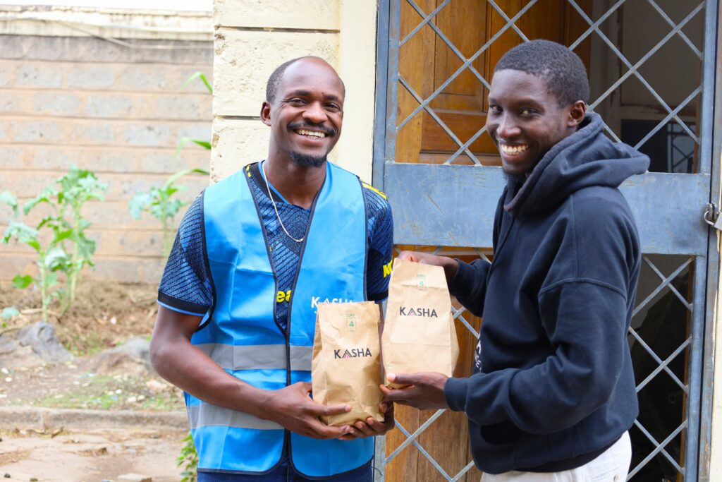 Two men smile with KASHA brown bags.