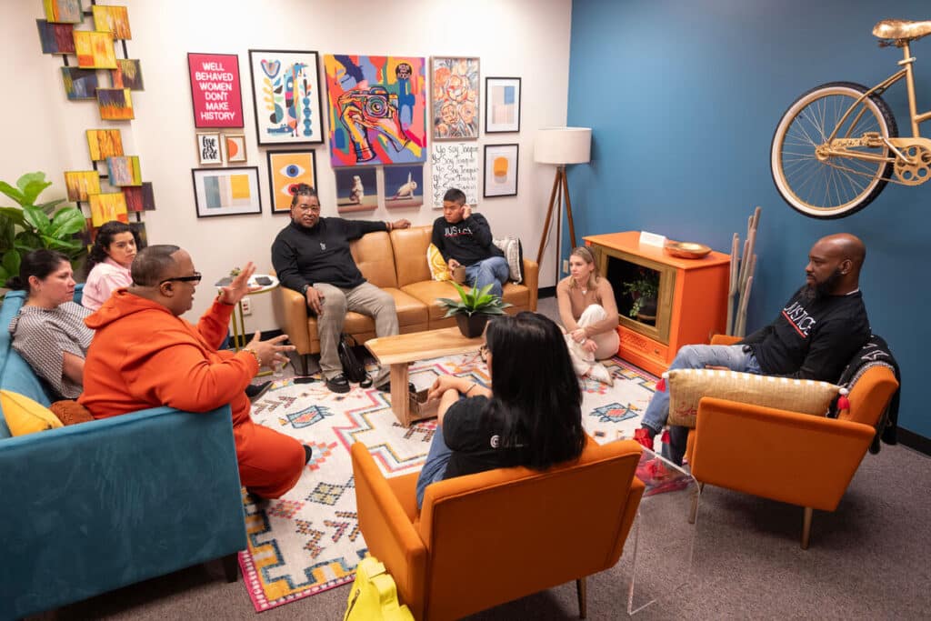 Group of people sit having a discussion.