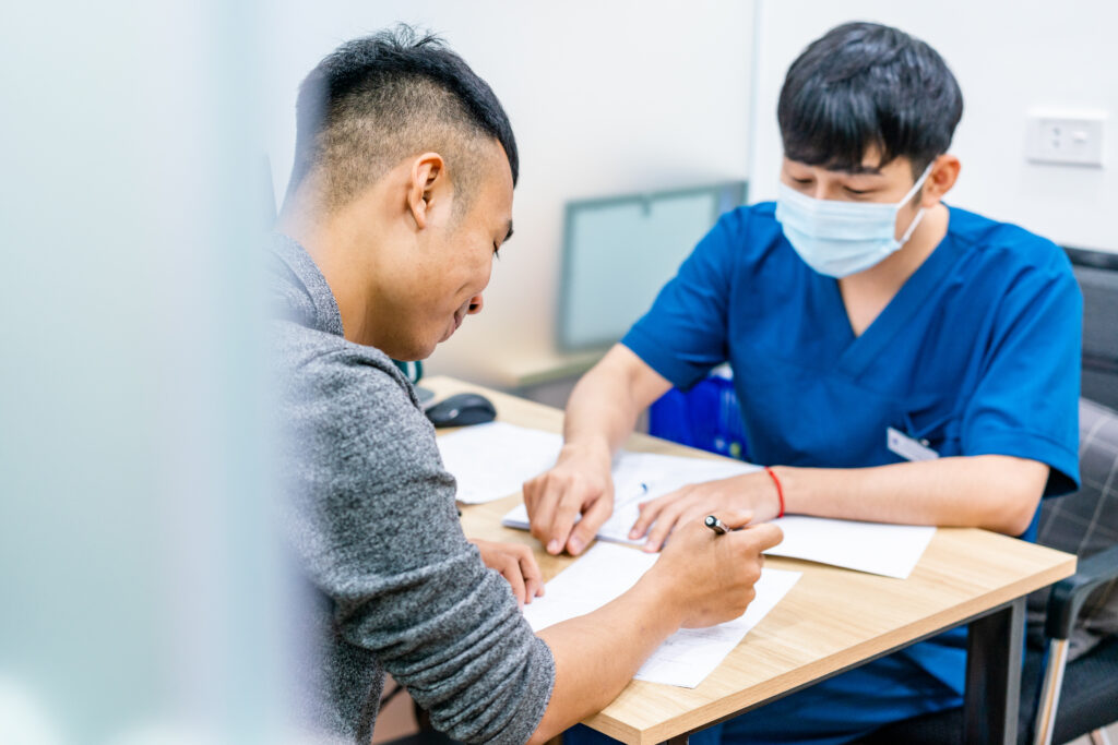 Counselor sits at a table with a client.