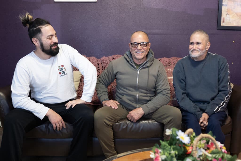 Will, Carmelo and Reuben sit on a sofa at a transition home run by San Antonio AIDS Foundation.